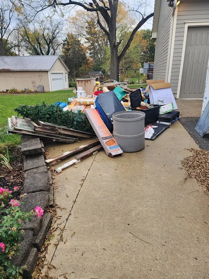 Dumpster being loaded with debris for Estate Cleanout Dumpster Rental in Youngsville